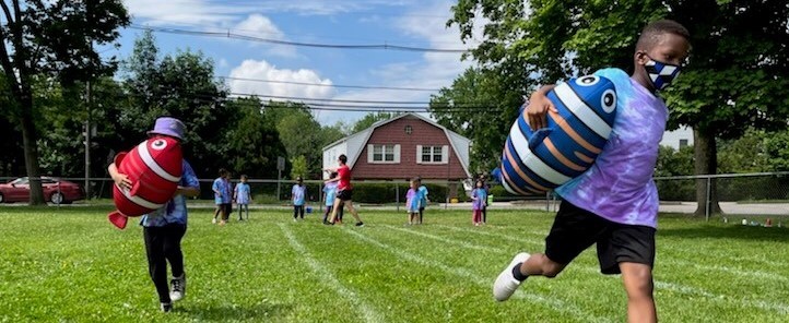 Students Running While Holding Stuffed Fish